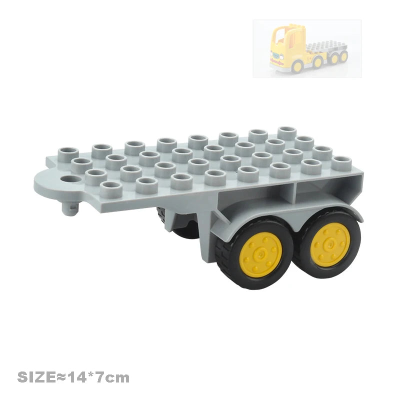 A gray city traffic building block set featuring vehicles and a trailer on train-like wheels.