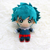 A teal-haired anime plush figure with large eyes and a blue outfit resting on a white fluffy surface.