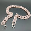 A flexible pink acrylic bag chain strap with metal clips is displayed against a gray background.
