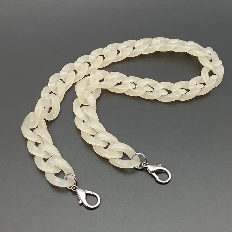 A flexible, light cream-colored acrylic bag chain strap with metal clips.