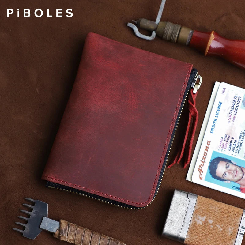 A dark red leather coin purse with a zipper is shown next to a knife and a driver's license.