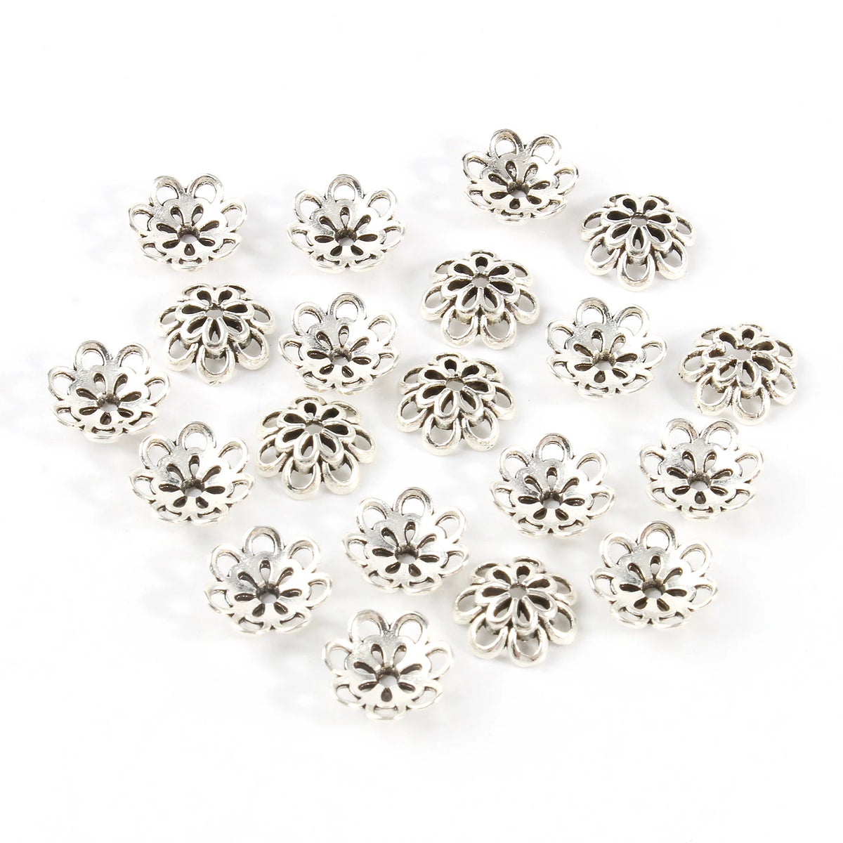A collection of silver Tibetan style hollow flower bead caps for jewelry making