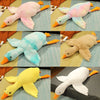 Three oversized plush geese in pink, light blue, and yellow colors shown lying down.