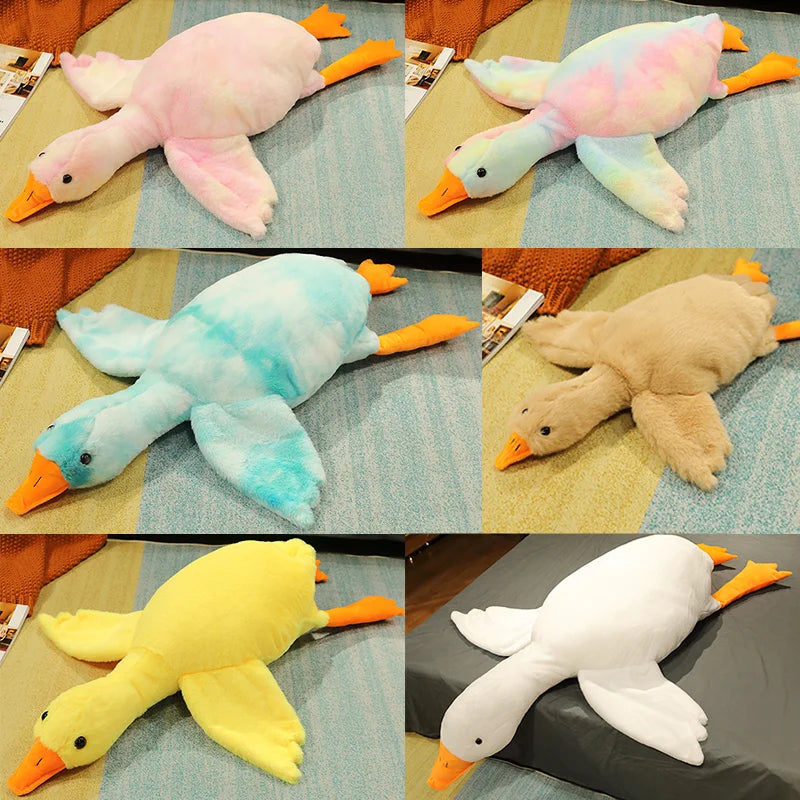 Three oversized plush geese in pink, light blue, and yellow colors shown lying down.