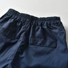 Navy blue boys' formal wedding outfit set including a shirt, shorts, and suspenders.