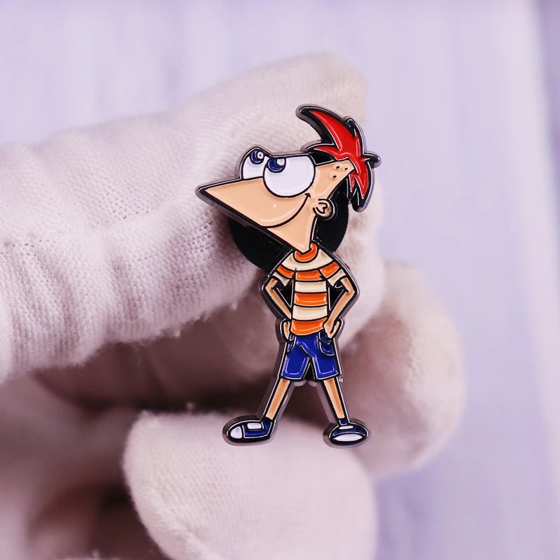 A hand wearing a white glove holds an enamel pin of the cartoon character Phineas.