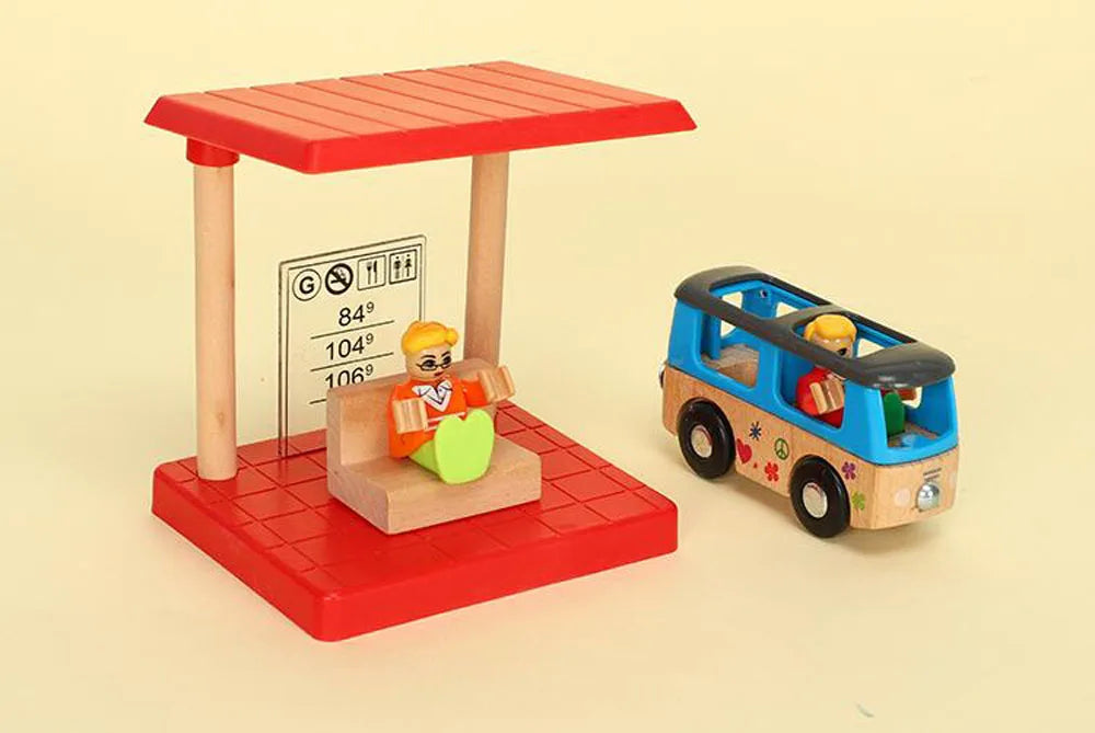 A wooden train track accessory set featuring an airport and gas station scene with a red platform and a blue train.