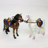 A 1/12 scale dollhouse horse with a brown coat and a white horse with a purple bridle and saddle accessories.