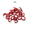 A pile of red metal open jump rings for DIY jewelry making.