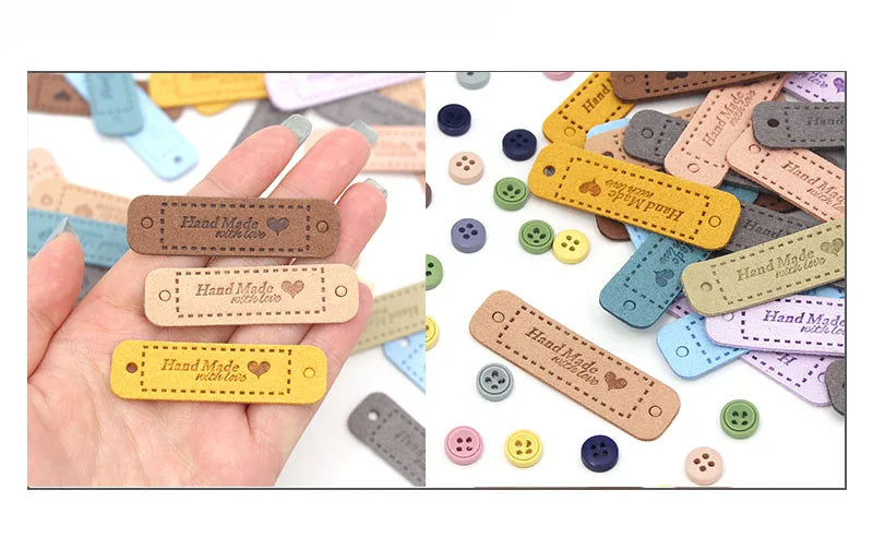 A hand holds a collection of 20 leather-style handmade with love tags in various colors and shapes for crafts.