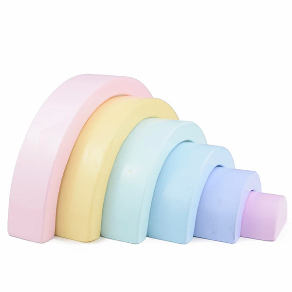A set of five pastel-colored wooden rainbow building blocks arranged in a row.