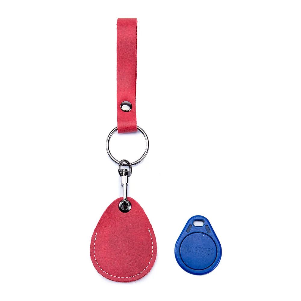 A red leather strap attached to a key ring and a matching oval leather tag for a vintage cowhide key wallet.