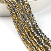 A close-up of multiple strands of faceted crystal glass beads in gold and gray tones for jewelry making