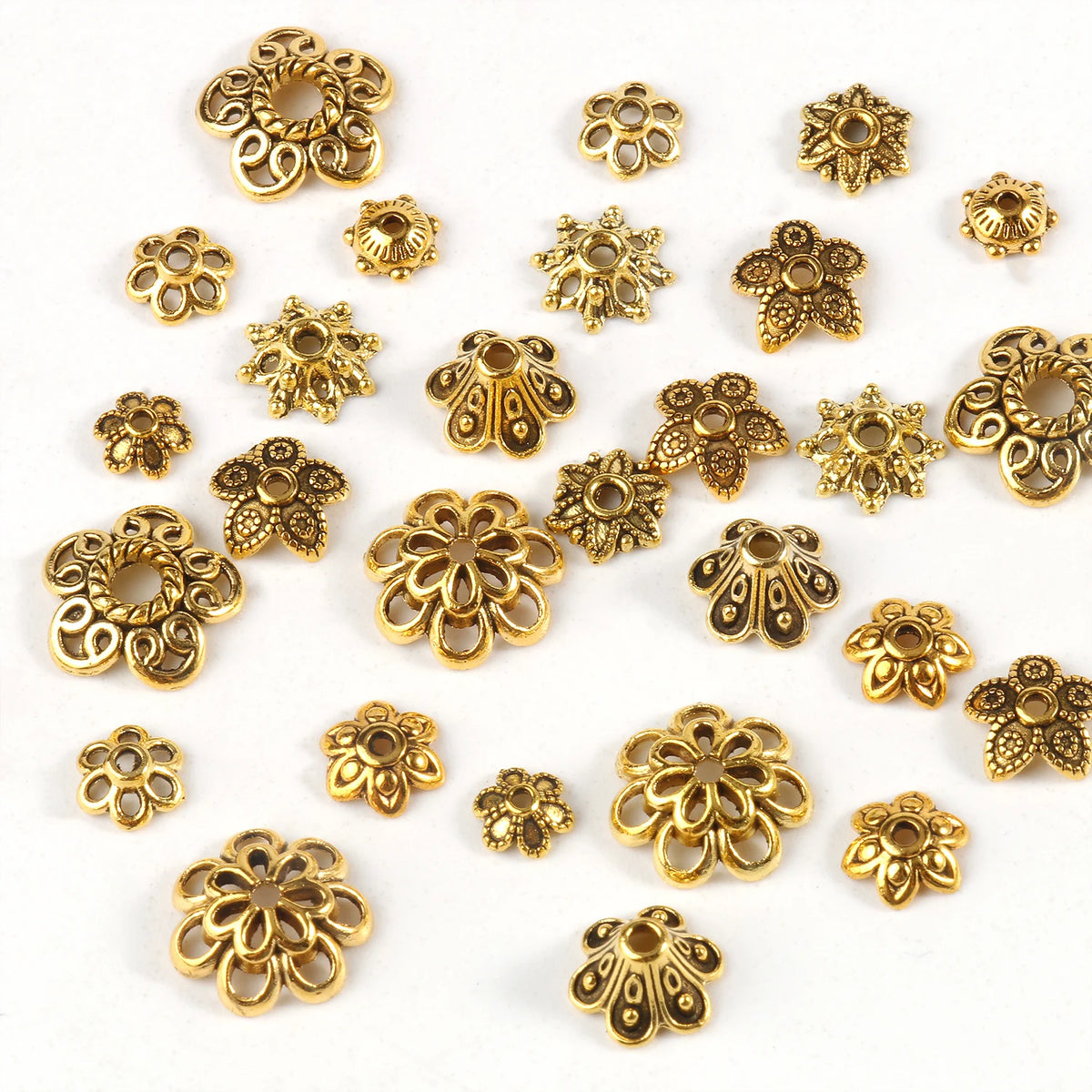 A collection of small, gold-colored Tibetan style hollow flower bead caps for jewelry making.