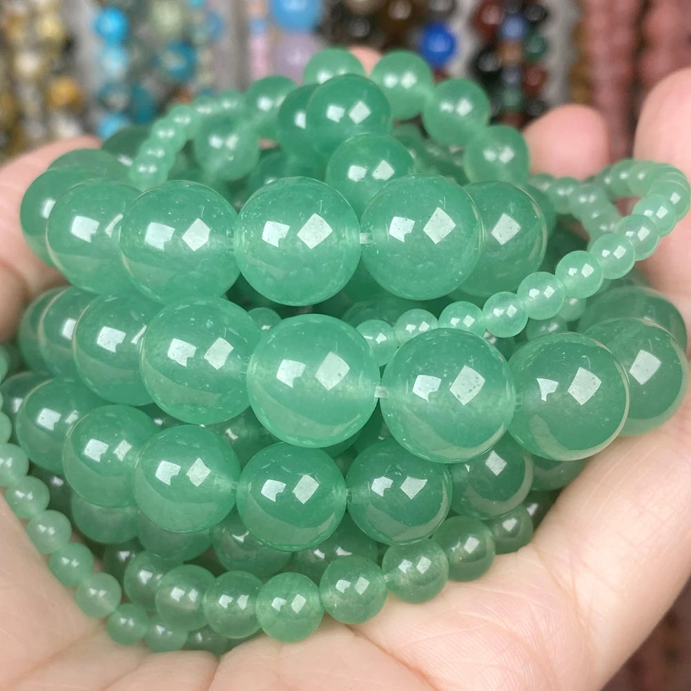 A handful of round, translucent green gemstone beads for jewelry making