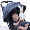 A baby is seated in a dark gray fabric baby carrier or security toy with a bunny plush comforter.