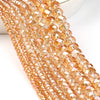 A close-up of multiple strands of faceted amber crystal glass beads for jewelry making