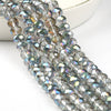A close-up of silver-toned faceted crystal glass beads strung together for jewelry making.