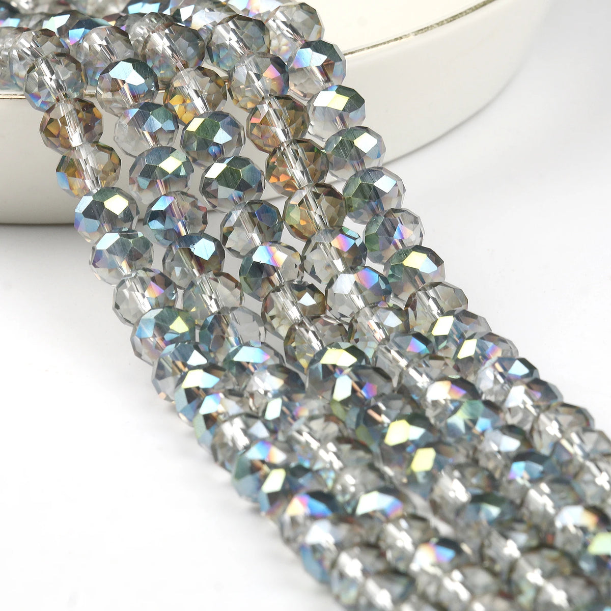 A close-up of silver-toned faceted crystal glass beads strung together for jewelry making.