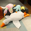 A collection of oversized kawaii goose plush pillows in various pastel colors including pink, blue, yellow, and white.