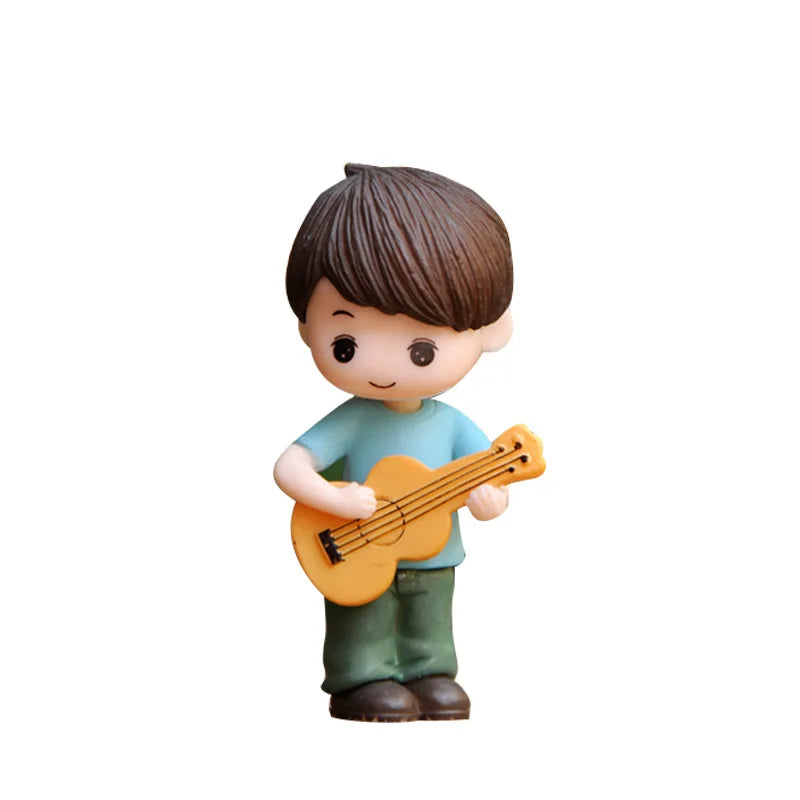 A figurine of a boy with brown hair wearing a blue shirt holding a yellow ukulele.