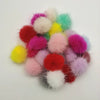 A collection of colorful, fluffy mink fur pom poms in shades of pink, red, yellow, and white.