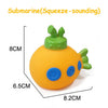 An orange rubber bath toy shaped like a cartoon animal with green features and blue eyes.