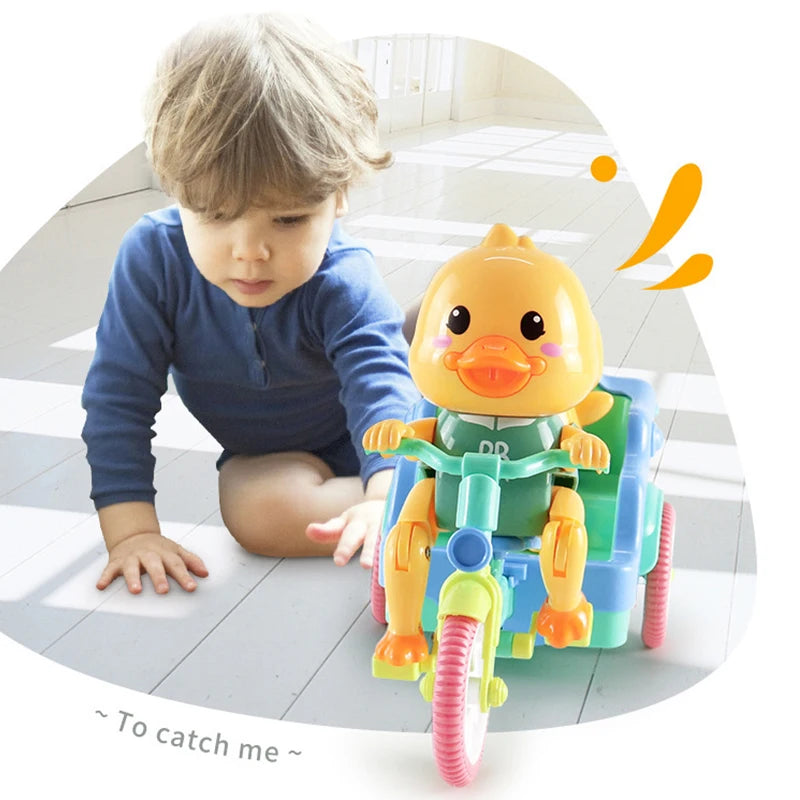 A young child is interacting with a yellow duck electric tricycle in a bright indoor setting.