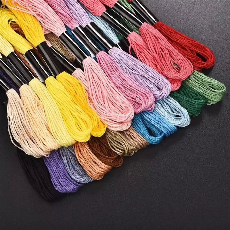 A collection of multicolor embroidery thread skeins in various shades of pink, yellow, green, and blue.