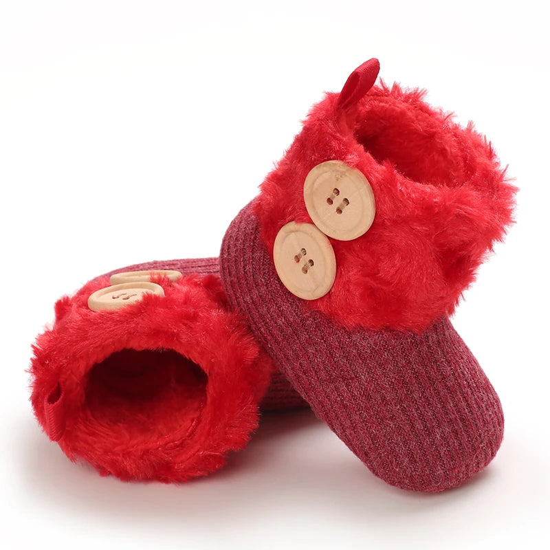 A pair of red fuzzy animal-themed baby first walker shoes with wooden buttons.