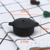A black miniature copper soup pot with measurements indicating its size.