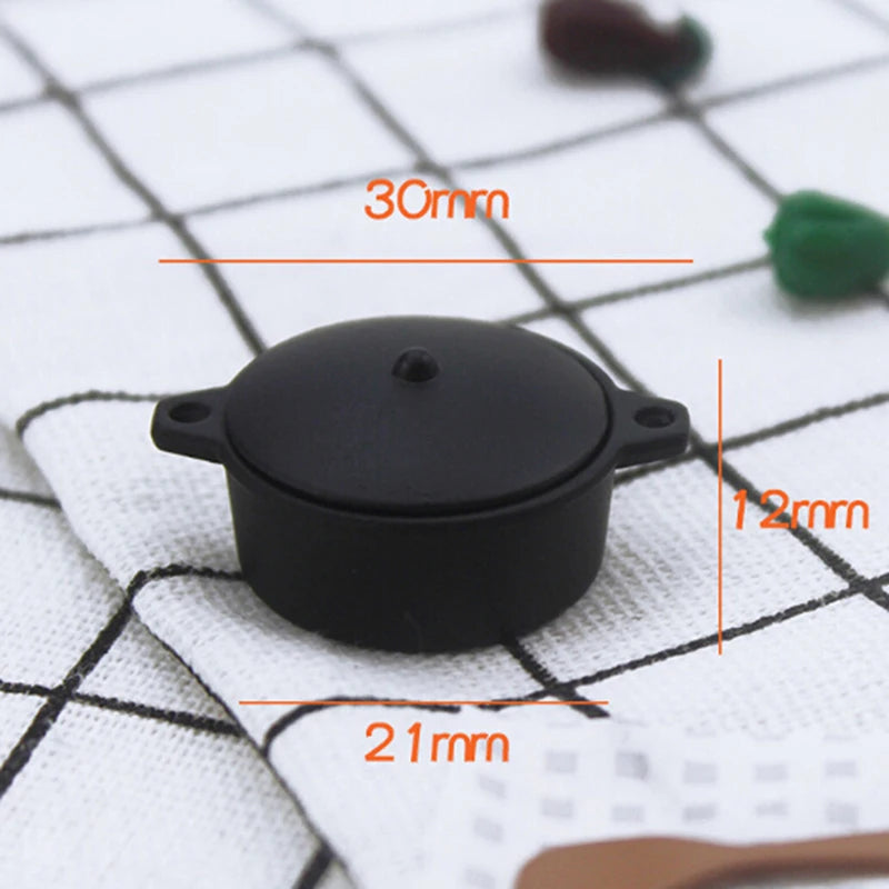 A black miniature copper soup pot with measurements indicating its size.