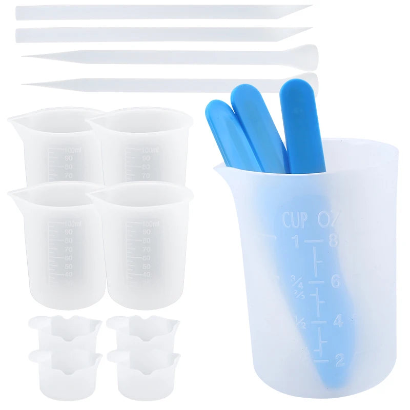 A set of reusable silicone resin mixing tools including measuring cups and blue stir sticks.