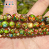 A hand holds a string of natural sea sediment jasper and turquoise beads for jewelry making