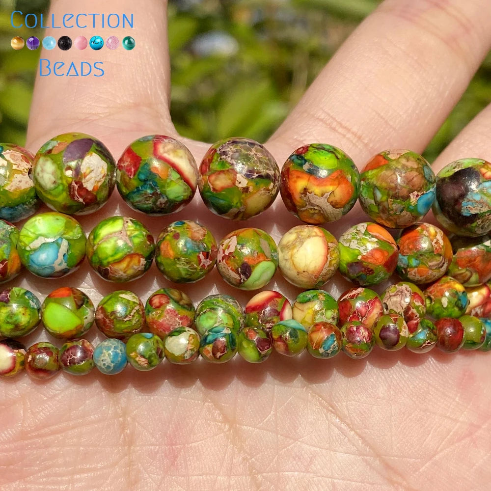 A hand holds a string of natural sea sediment jasper and turquoise beads for jewelry making