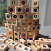 A tower of wooden gemstone building blocks featuring various colored acrylic crystals.
