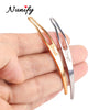 A pair of stainless steel interlocking needles for jewelry maintenance are held in a person's hand.