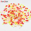 Assortment of small, colorful soft polymer clay slices in red, pink, and yellow for nail art and DIY crafts.
