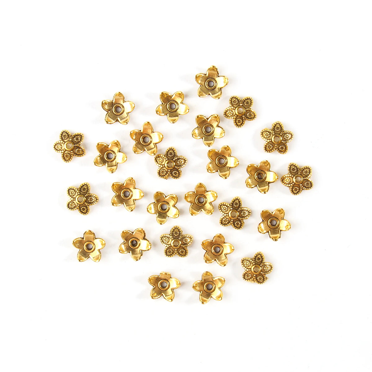 A collection of small, gold-colored Tibetan style hollow flower bead caps for jewelry making.