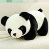 A white and black panda plush toy with large ears resting on a light-colored fabric.