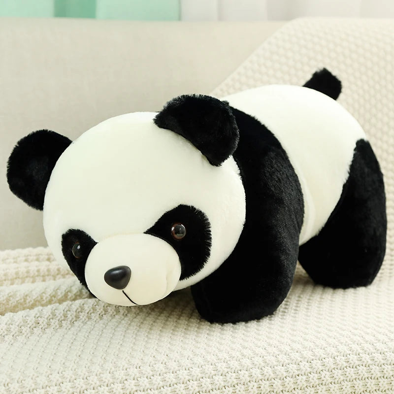 A white and black panda plush toy with large ears resting on a light-colored fabric.