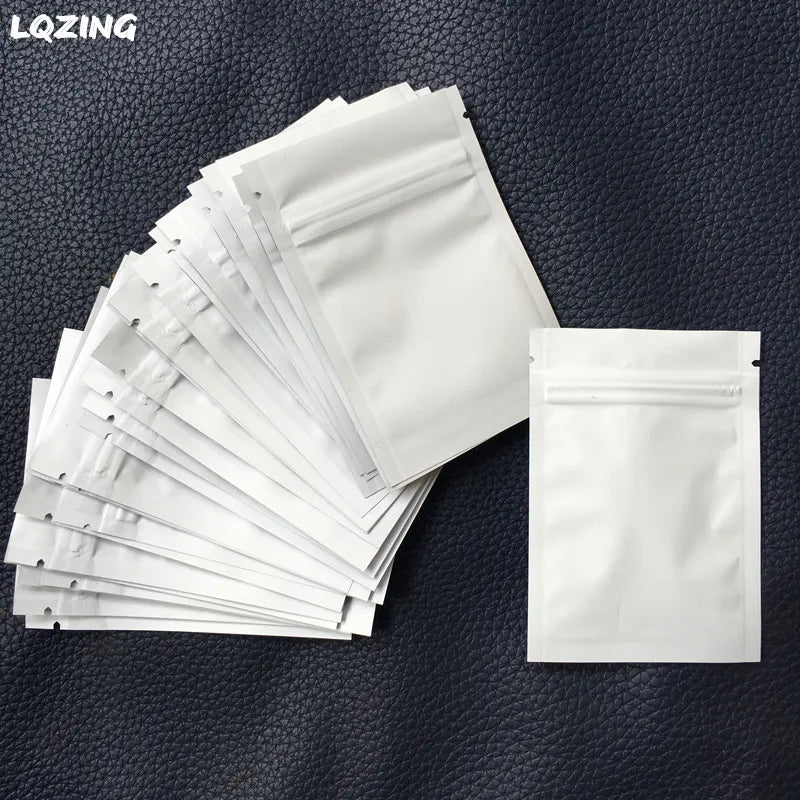 A stack of white mini reusable ziplock bags is displayed on a dark surface.