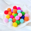 A collection of brightly colored acrylic pearl beads in various shades including red, orange, purple, pink, green, and blue s
