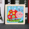 A wooden tangram puzzle featuring a red ladybug and a pink insect on a green landscape.