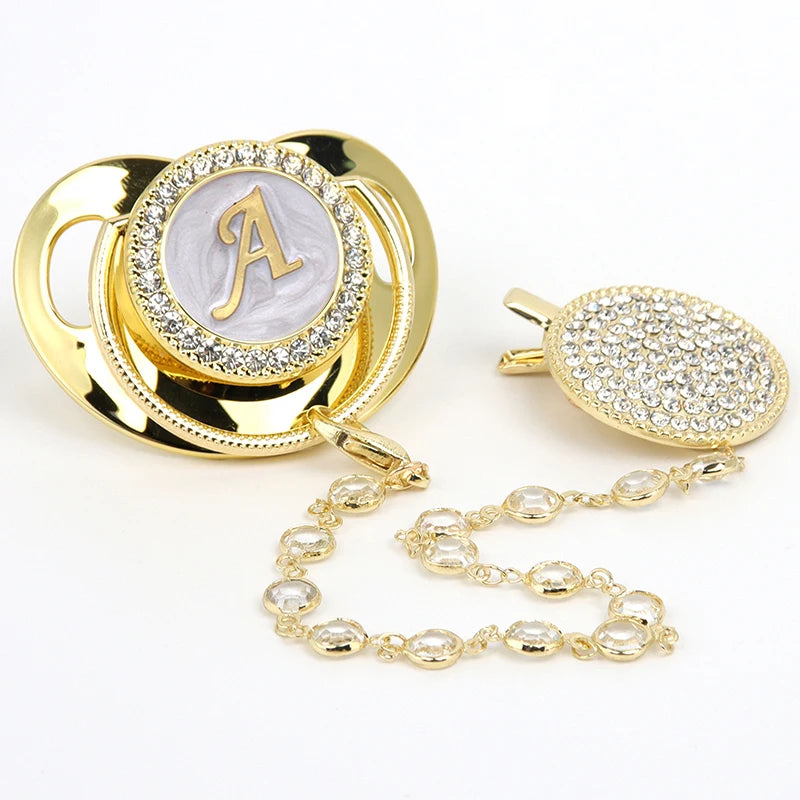 Gold initial rhinestone pacifier with clip featuring an 'A' design on a silicone disc