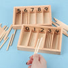 A wooden Montessori math learning set featuring a spindle box with numbered geometric shapes and wooden sticks.