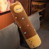A long, cylindrical stuffed animal plush pillow resembling a bear, colored brown and yellow, with small colorful hearts scatt