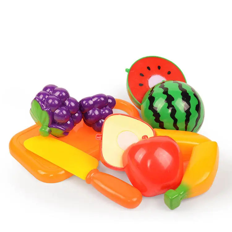 A set of colorful pretend play food toys including a watermelon slice, purple grapes, and yellow bell pepper.