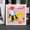 A wooden tangram puzzle featuring a yellow bee design on a pink background.