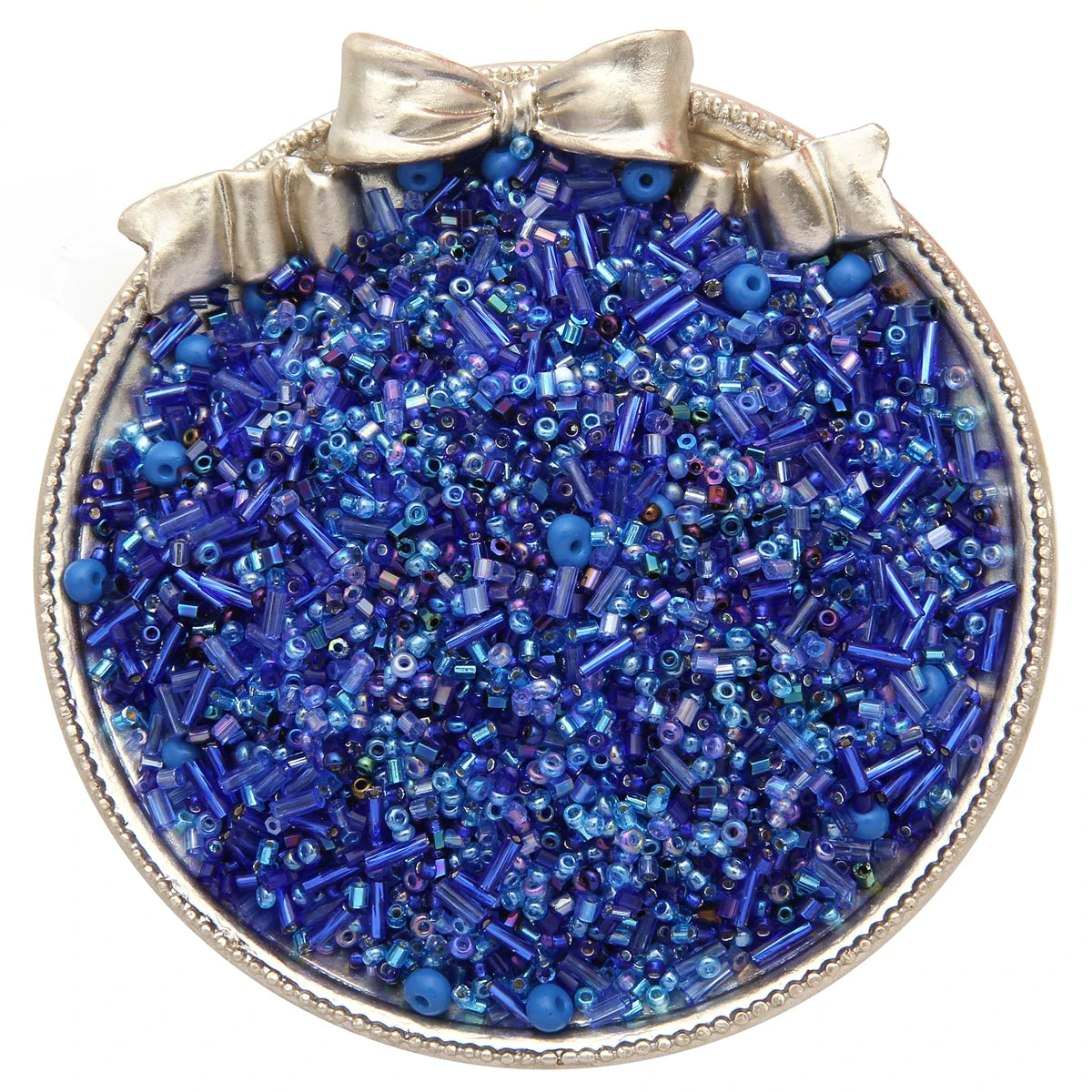 Un plat à bordure argentée rempli de perles de verre bleues et violettes pour la création